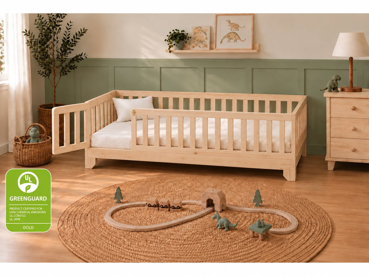Luca Montessori twin size floor bed for toddlers with a natural finish, rails and a gate in a sage green boys bedroom.