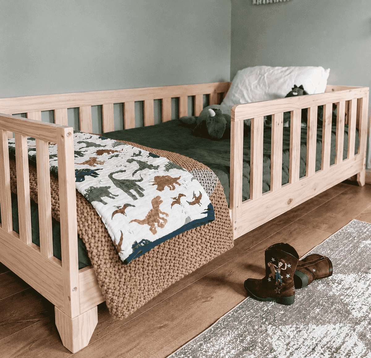 Luca Convertible Montessori Toddler Bed. A twin size floor bed with rails shown in a Toy Story Toddler Boys Room.