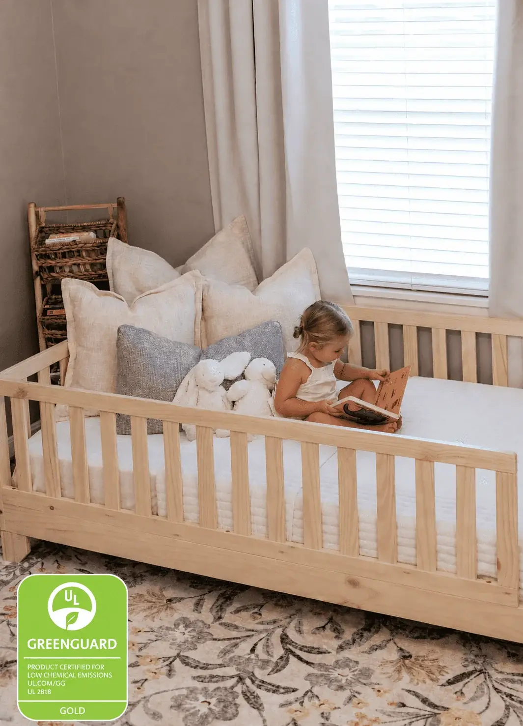 Natural wood Luca Montessori floor bed with safety rails in a toddler bedroom