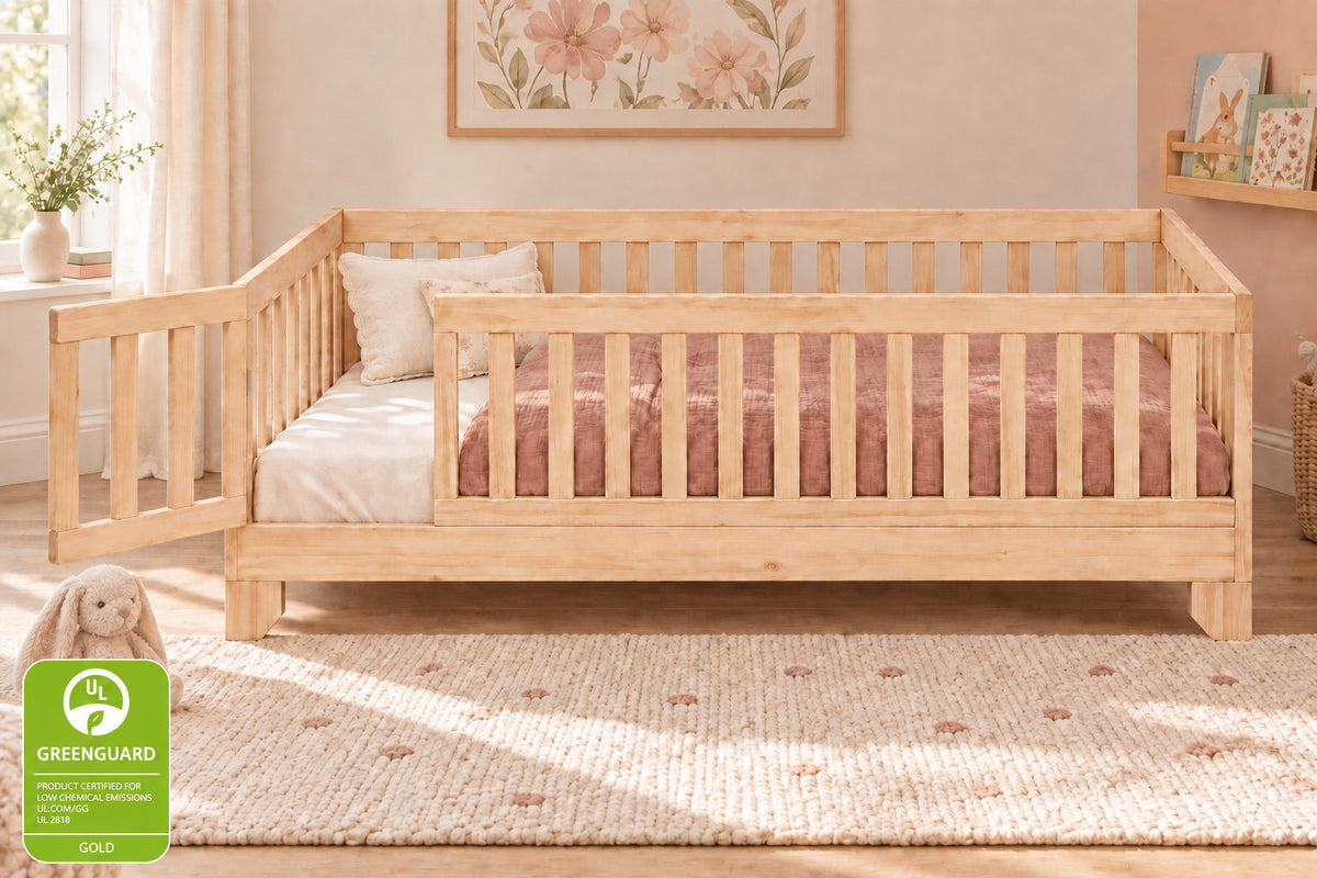 Luca twin size natural finish toddler floor bed with gate and guard rails in a toddler girls dusty rose bedroom.