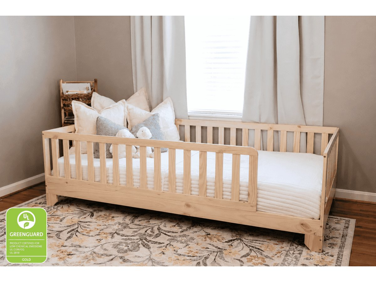 Luca natural Twin XL Montessori floor bed with rails beside a bedroom window